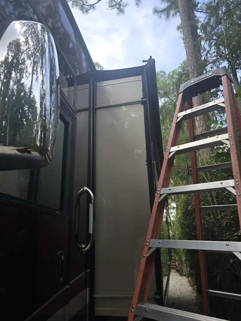 Triton RV technician working on a stuck slide-out at a Florida campsite